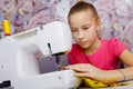 A teenage girl learns to sew