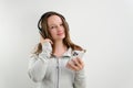 teenage girl listens to music in large professional headphones on a white background sports suit gently smiles beautiful Royalty Free Stock Photo
