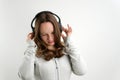 teenage girl listens to music in large professional headphones on a white background sports suit gently smiles beautiful Royalty Free Stock Photo