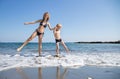 teenage girl and little boy, adult sister and brother, are standing in bathing suits in sea , splashing water Royalty Free Stock Photo