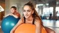 Teenage girl looking at camera while working out using exercise ball in gym. Sport, healthy lifestyle, physical Royalty Free Stock Photo