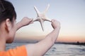 Teenage girl looking and holding up starfish Royalty Free Stock Photo