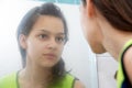 Teenage girl looking in mirror