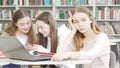 Teenage girl looking tired and bored while studying at the library