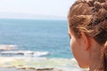 A teenage girl looks at the sea below Royalty Free Stock Photo