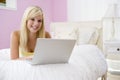 Teenage Girl Lying On Bed Using Laptop Royalty Free Stock Photo