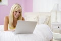 Teenage Girl Lying On Bed Using Laptop Royalty Free Stock Photo