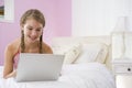 Teenage Girl Lying On Bed Using Laptop Royalty Free Stock Photo