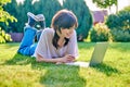 Teenage girl lying on the grass using a laptop Royalty Free Stock Photo