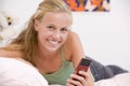 Teenage Girl Lying On Her Bed Using Mobile Phone Royalty Free Stock Photo