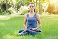 Teenage girl meditates in a garden