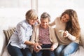 A teenage girl, mother and grandmother with tablet at home. Royalty Free Stock Photo