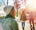 Teenage girl in nature with friends, walk in park with autumn and sunshine, wellness with happiness. Youth outdoor