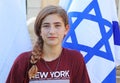 A teenage girl next to an Israeli flag