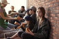 Teenage girl with other poor people receiving food from volunteers