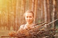 Teenage girl with pimple skin collect branches firewood for campfire while traveling through summer forest in nature. young happy Royalty Free Stock Photo