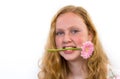 Teenage girl with pink flower in mouth