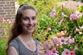 Teenage girl and pink mandevilla Royalty Free Stock Photo