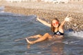 Teenage girl in pink sunglasses having fun on the beach in the sea, playing with splashes. Fun on summer hloiday concept Royalty Free Stock Photo
