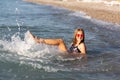 Teenage girl in pink sunglasses having fun on the beach in the sea, playing with splashes. Fun on summer hloiday concept Royalty Free Stock Photo