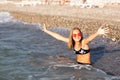 Teenage girl in pink sunglasses having fun on the beach in the sea, playing with splashes. Fun on summer hloiday concept Royalty Free Stock Photo