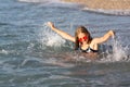 Teenage girl in pink sunglasses having fun on the beach in the sea, playing with splashes. Fun on summer hloiday concept Royalty Free Stock Photo