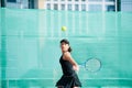 Teenage girl playing tennis on a new court, doing wide swing