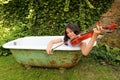 Teenage girl playing violin outdoor in bathtub Royalty Free Stock Photo