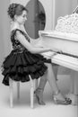 A teenage girl is playing on a white grand piano. Royalty Free Stock Photo