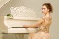 A teenage girl is playing on a white grand piano. Royalty Free Stock Photo