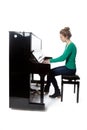 Teenage girl plays piano in green shirt Royalty Free Stock Photo