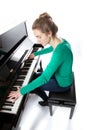 Teenage girl plays piano in green shirt Royalty Free Stock Photo