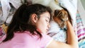 Teenage girl with ponytail and small puppy sleep on blanket