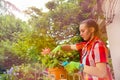 Teenage girl pruning potted plant in the garden