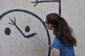 Teenage girl repairs wallpainting