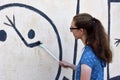 Teenage girl repairs wallpainting