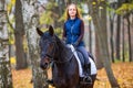 Teenage girl riding horse in autumn park Royalty Free Stock Photo
