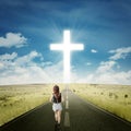 Teenage girl on the road with a cross Royalty Free Stock Photo