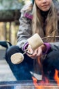 Teenage girl roasting large marshmallow on a stick over the campfire firepit. Camping family fun Royalty Free Stock Photo