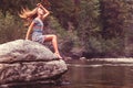 Teenage girl on a rock in river