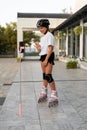 Teenage girl roller skating, actively relaxing in the park, recording a live broadcast on social networks for her Royalty Free Stock Photo