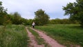 A teenage girl runs on a footpath in a field.