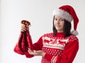 A teenage girl in a Santa Claus hat and a red Christmas sweater holds a red bag with a gift. The concept of Christmas and New Year Royalty Free Stock Photo