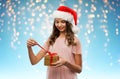 Teenage girl in santa hat opening christmas gift Royalty Free Stock Photo