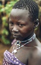 TOPOSA TRIBE, SOUTH SUDAN - MARCH 12, 2020: Teenage girl with scarred face and traditional accessories looking away while living