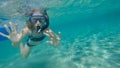 Teenage girl with scuba mask having fun and looking at the camera under the water surface.