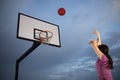 Girl shooting a basketball at an outdoor court