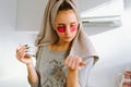 teenage girl, after shower, wearing patches under eyes, drinks coffee in home kitchen. Royalty Free Stock Photo