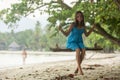 A teenage girl sits on a swing on a tropical beach. Royalty Free Stock Photo