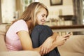 Teenage Girl Sitting On Sofa At Home Texting On Mobile Phone Royalty Free Stock Photo